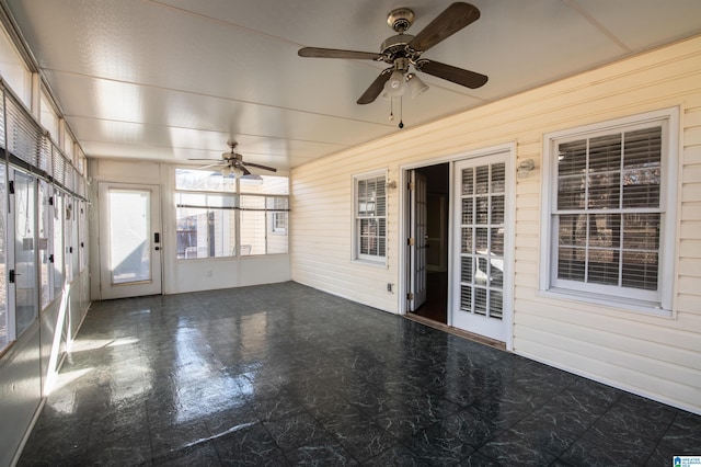 unfurnished sunroom featuring ceiling fan