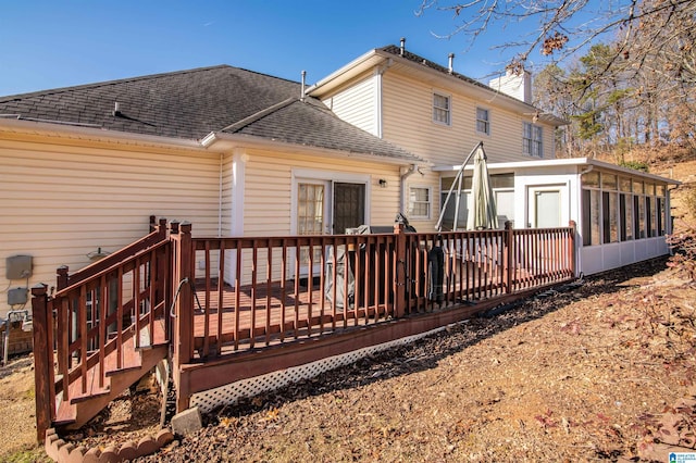 rear view of property with a wooden deck and a sunroom