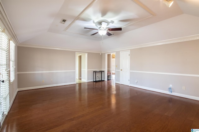 unfurnished room featuring ceiling fan, a raised ceiling, dark wood-type flooring, and crown molding