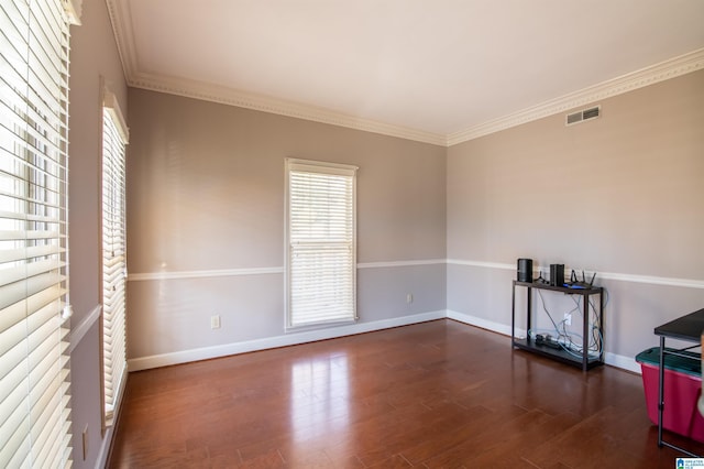 empty room with dark hardwood / wood-style floors and crown molding