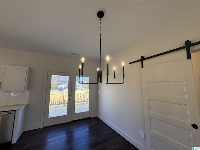 unfurnished dining area featuring a barn door and dark wood-type flooring