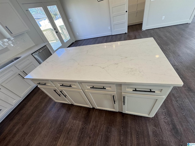 kitchen with light stone countertops, french doors, white cabinets, and dark hardwood / wood-style floors