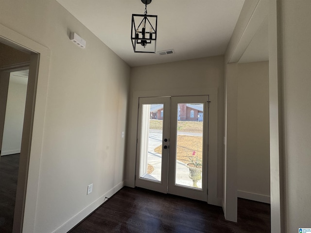 entryway with a notable chandelier and dark hardwood / wood-style flooring