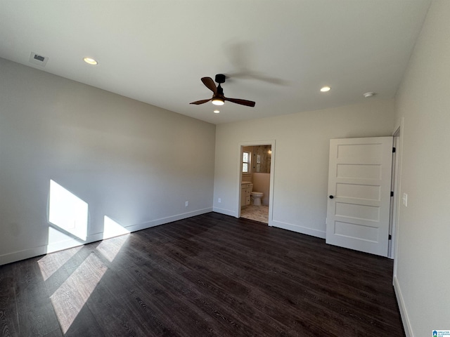 unfurnished bedroom featuring dark hardwood / wood-style flooring, ensuite bath, and ceiling fan