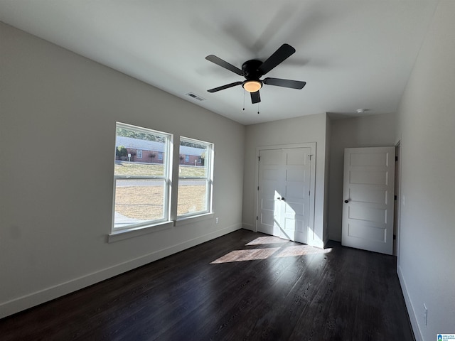 unfurnished bedroom featuring dark hardwood / wood-style flooring, a closet, and ceiling fan