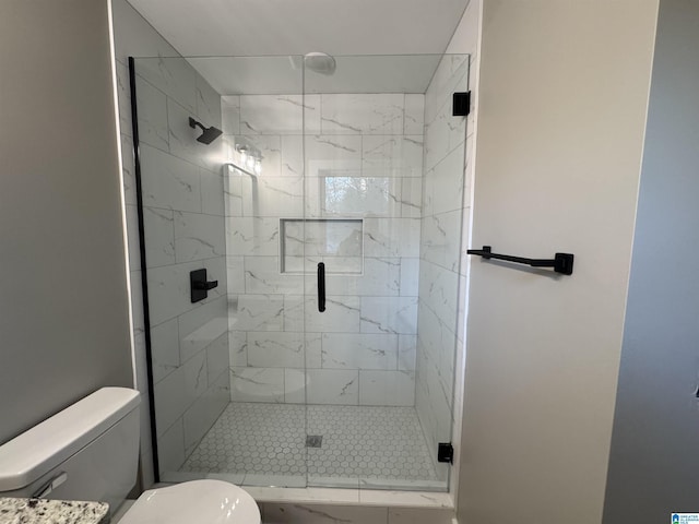 bathroom featuring toilet and a shower with door