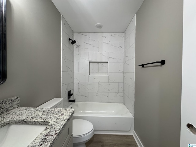 full bathroom featuring toilet, tiled shower / bath combo, wood-type flooring, and vanity