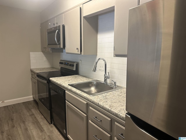 kitchen with backsplash, dark hardwood / wood-style flooring, sink, and stainless steel appliances