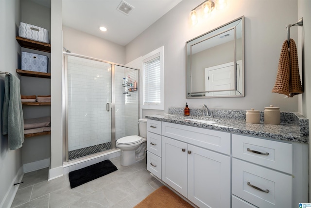 bathroom with tile patterned flooring, a shower with door, vanity, and toilet