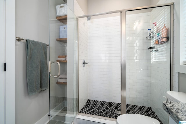 bathroom with toilet and a shower with shower door