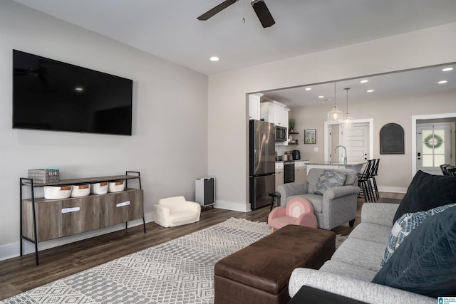 living room with ceiling fan, dark hardwood / wood-style flooring, and sink