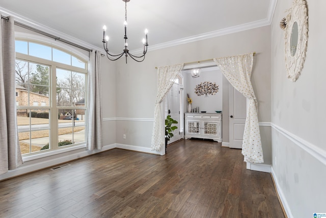 unfurnished dining area with an inviting chandelier, dark wood-style floors, baseboards, and ornamental molding