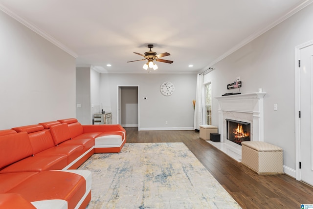 living area with a high end fireplace, ornamental molding, baseboards, and wood finished floors