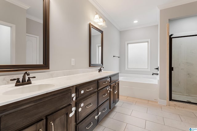 full bathroom with double vanity, ornamental molding, a sink, a shower stall, and a garden tub