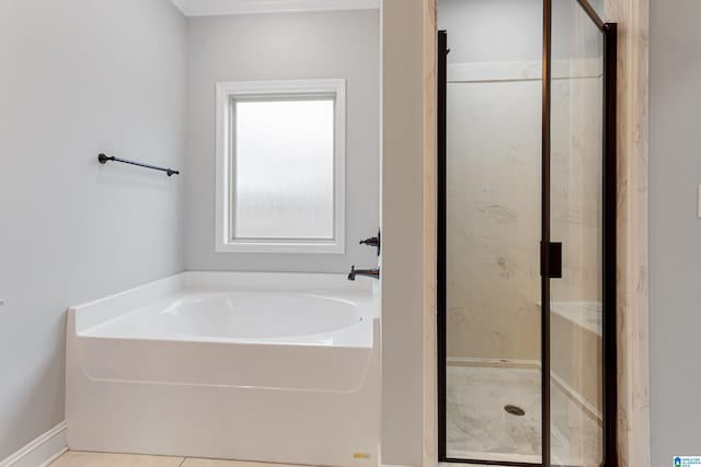 bathroom featuring tile patterned flooring, a garden tub, and a stall shower