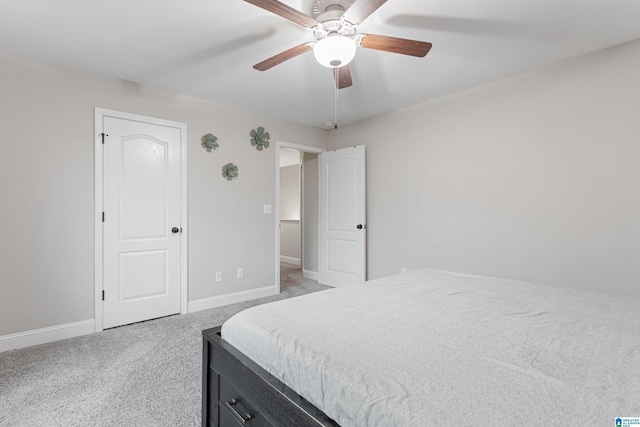 bedroom featuring a ceiling fan, light colored carpet, and baseboards