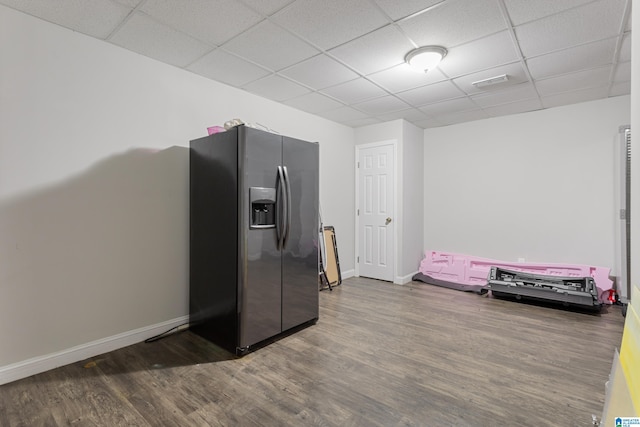 kitchen with visible vents, wood finished floors, stainless steel fridge, a paneled ceiling, and baseboards