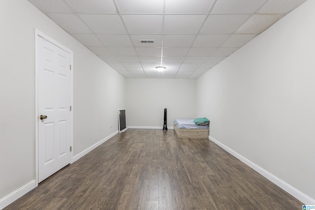 empty room featuring a drop ceiling, baseboards, visible vents, and dark wood-style flooring