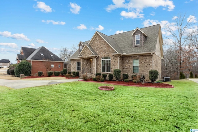 view of front of property with a front lawn, cooling unit, brick siding, and a shingled roof