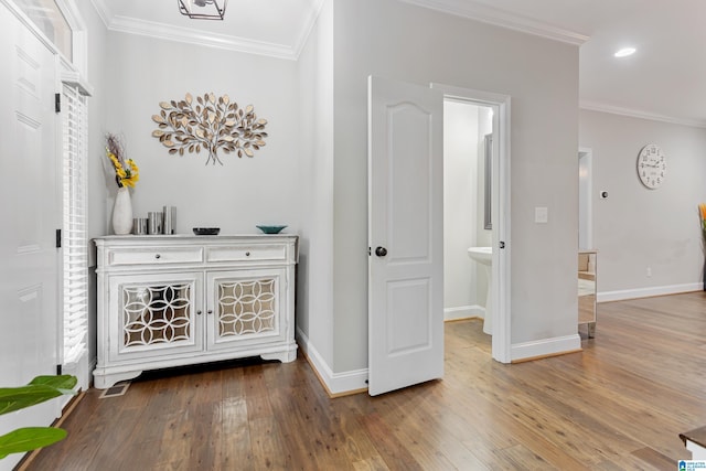 hallway with crown molding, hardwood / wood-style flooring, and baseboards