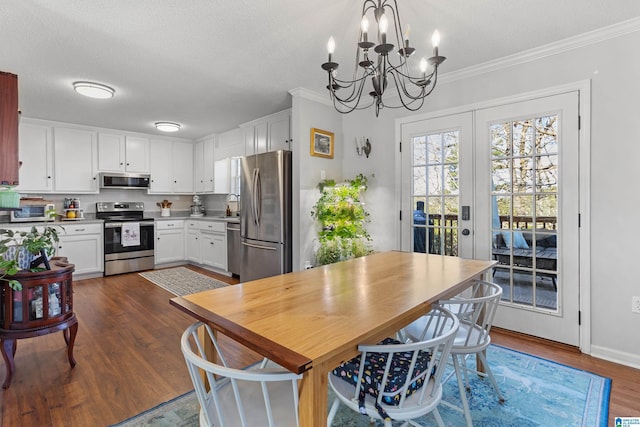 dining room featuring french doors, dark hardwood / wood-style flooring, a chandelier, a textured ceiling, and ornamental molding