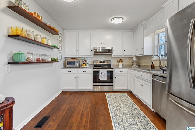 kitchen featuring sink, stainless steel appliances, light stone counters, a textured ceiling, and white cabinets