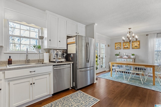 kitchen featuring stainless steel appliances, crown molding, dark wood-type flooring, sink, and white cabinetry