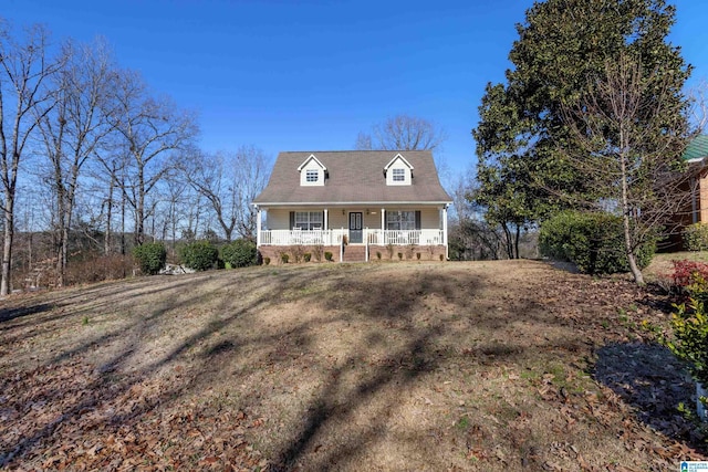 cape cod home featuring covered porch and a front lawn