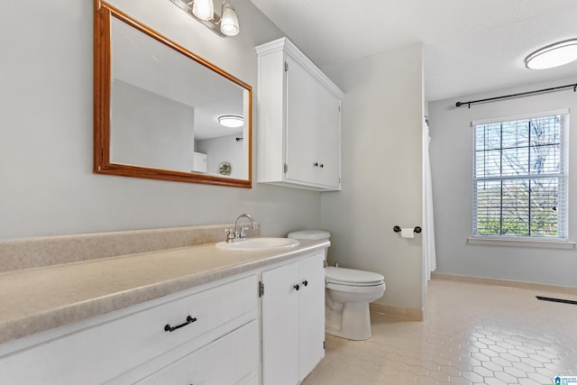 bathroom featuring tile patterned flooring, vanity, and toilet