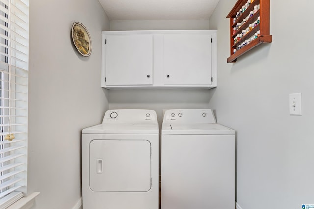 washroom with washer and clothes dryer and cabinets