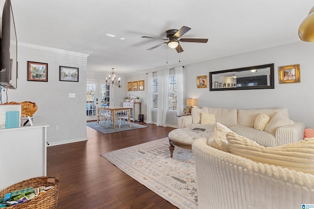 living room with a textured ceiling, ceiling fan with notable chandelier, dark hardwood / wood-style floors, and ornamental molding