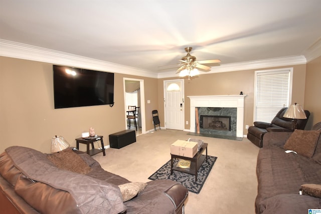 carpeted living room with ceiling fan, crown molding, and a high end fireplace