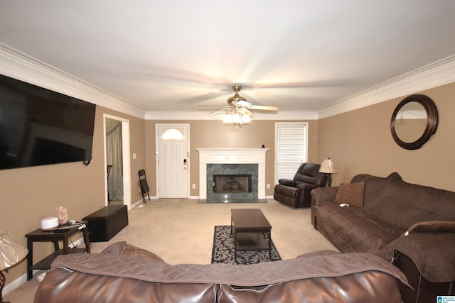 living room with ceiling fan, a high end fireplace, light colored carpet, and ornamental molding