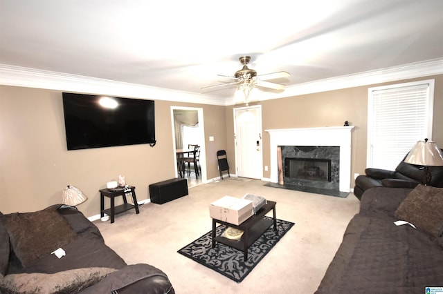 living room featuring crown molding, a high end fireplace, light carpet, and ceiling fan