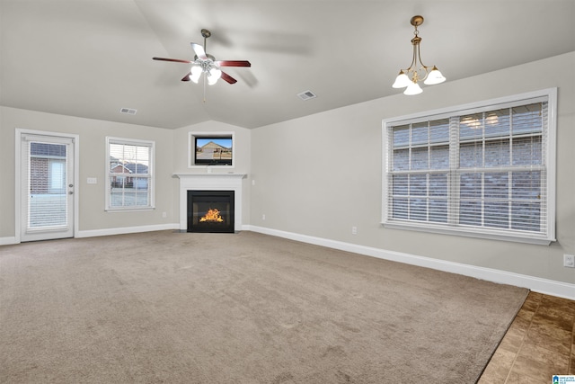 unfurnished living room with lofted ceiling and ceiling fan with notable chandelier