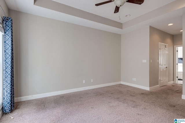 unfurnished room featuring carpet, ceiling fan, and a tray ceiling