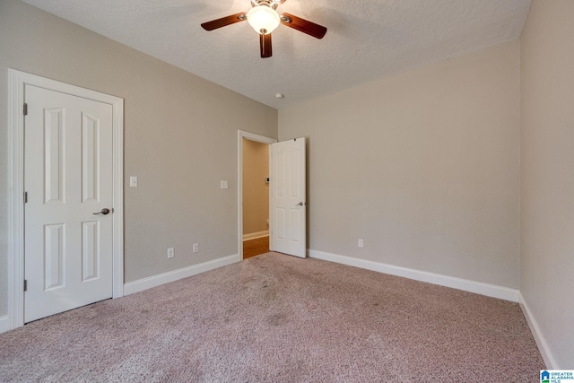 unfurnished bedroom featuring a textured ceiling, carpet floors, and ceiling fan