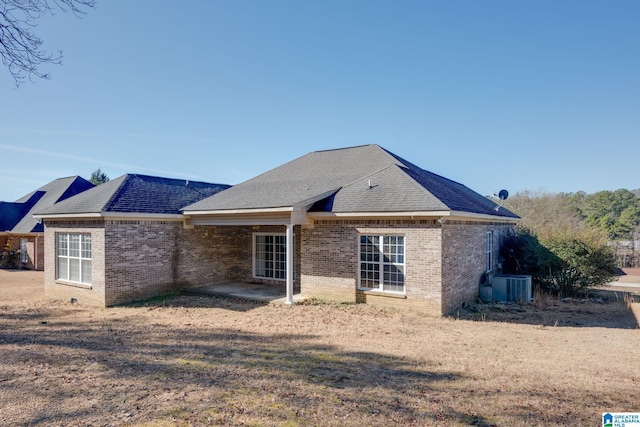 rear view of property featuring a lawn, central air condition unit, and a patio