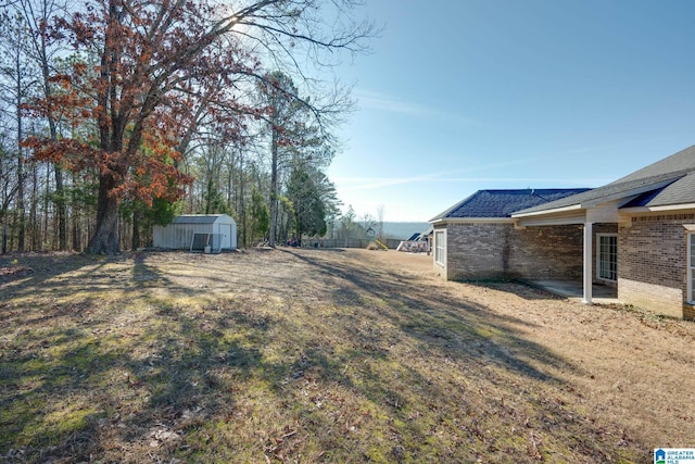 view of yard featuring a storage shed and a patio