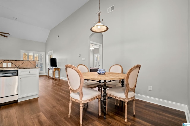 dining area with ceiling fan, high vaulted ceiling, and dark wood-type flooring