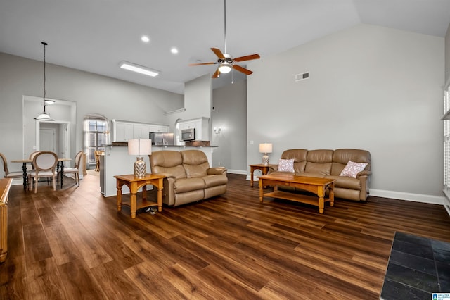 living room with ceiling fan, dark hardwood / wood-style flooring, and high vaulted ceiling