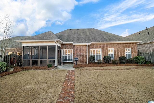 rear view of property with a sunroom and a lawn