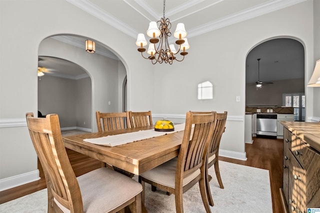 dining room featuring ceiling fan with notable chandelier, dark wood-type flooring, and ornamental molding