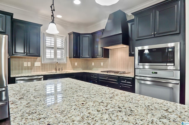 kitchen featuring sink, custom range hood, decorative backsplash, hanging light fixtures, and crown molding