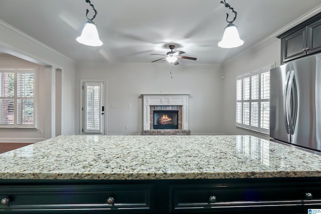 kitchen featuring a kitchen island, a brick fireplace, ceiling fan, and decorative light fixtures