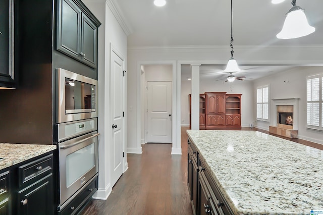 kitchen featuring light stone countertops, appliances with stainless steel finishes, and pendant lighting