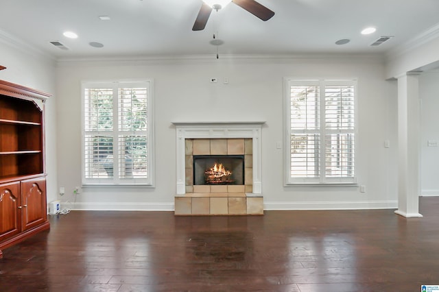 unfurnished living room with a tile fireplace, a healthy amount of sunlight, and crown molding