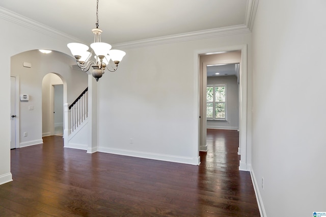 empty room with an inviting chandelier, ornamental molding, and dark hardwood / wood-style floors