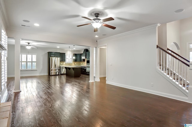 unfurnished living room featuring ceiling fan, dark wood-type flooring, and crown molding