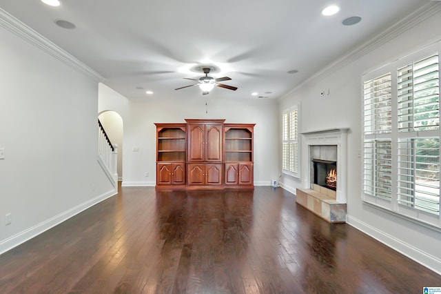 unfurnished living room featuring ceiling fan, dark wood-type flooring, and crown molding